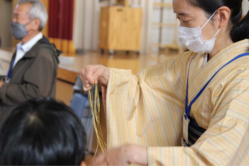 福岡市内の小学校での博多人形絵付け体験教室です。博多織で使う絹糸を子どもたちにプレゼントしました。